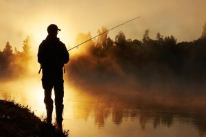 fisher fishing on foggy sunrise